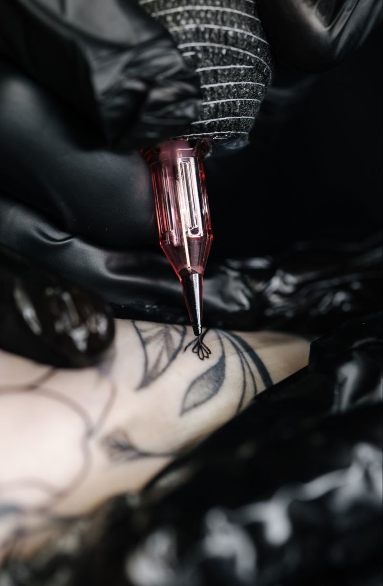 Máquina de tatuar a fazer o traço de uma linha na pele